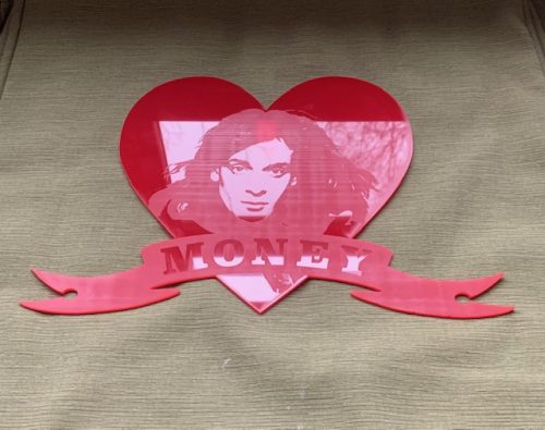 Acrylic wall hanging in the shape of a heart with a banner that says Money. The heart has an image of the singer Eddie Money on it.